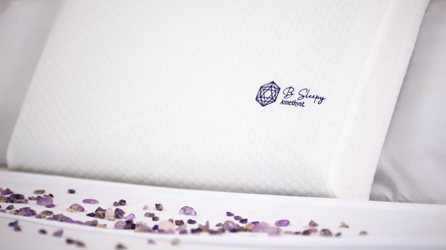 B Sleepy pillow with scattered amethyst crystals on bed linens